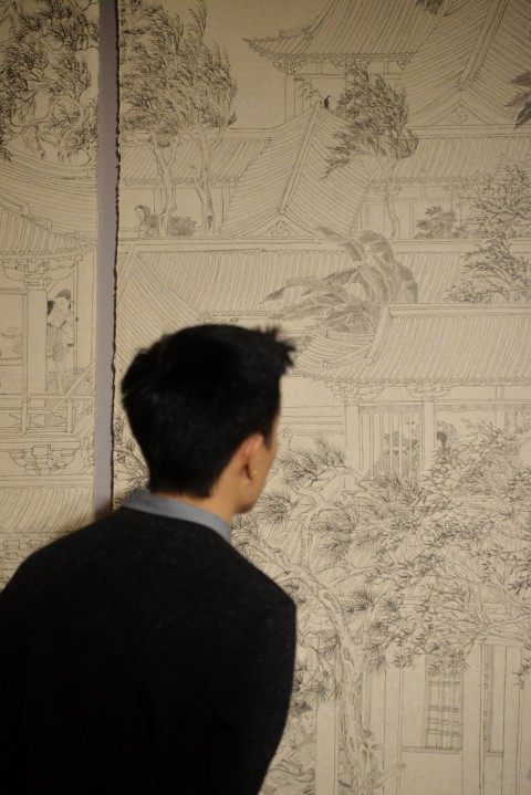 A man closing viewing the image from the art exhibit